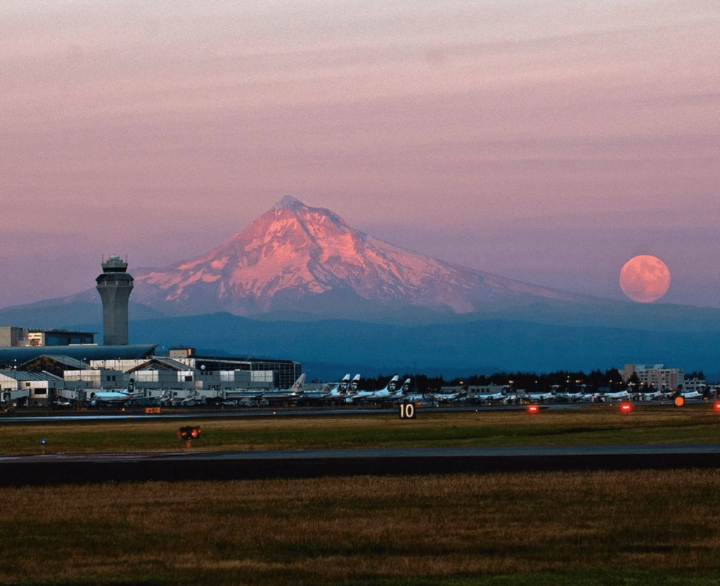 Vista del PDX y aviones al atardecer, con el Mt. Hood al fondo.